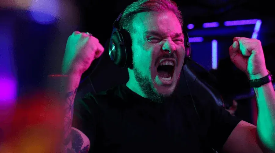 A happy man wearing headset and playing video games at Inferno Online